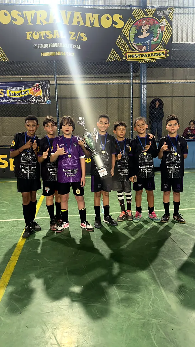 Atletas com troféu em torneio de futsal