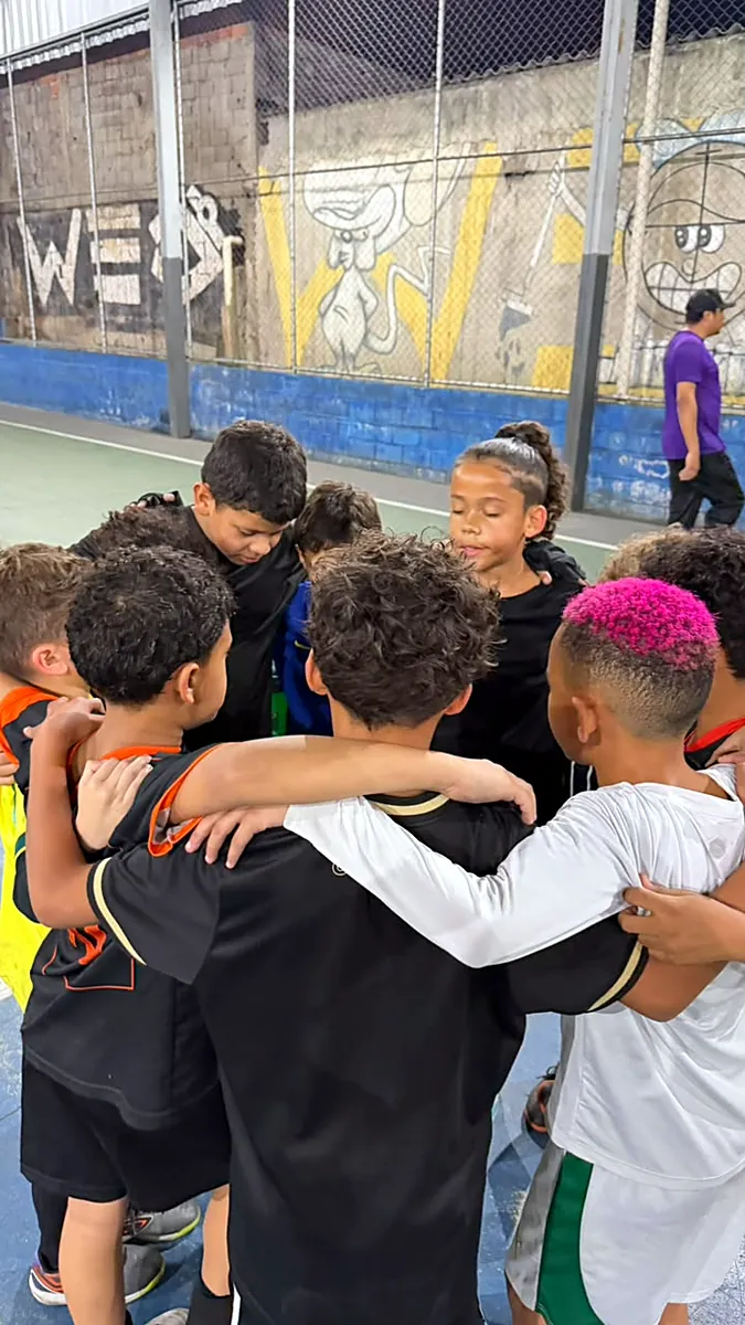 Atletas reunidos em roda durante o treino
